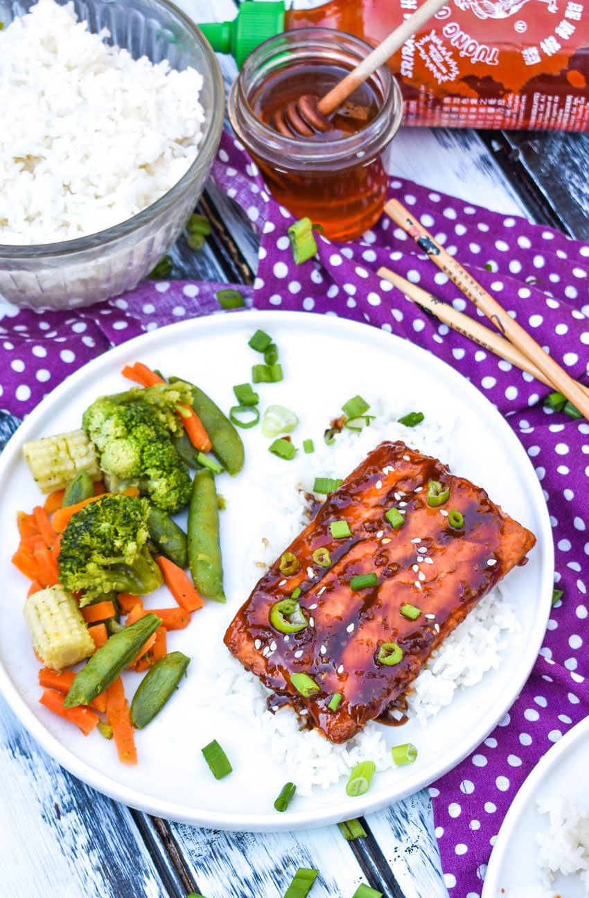 Sweet and spicy honey sriracha salmon is pure recipe magic full of bold yet balanced flavor. Salty soy sauce, sweet honey, spicy sriracha, the punch of fresh ginger, and the peppering of minced garlic meld to create a salmon that tastes like it came from your favorite fine dining restaurant.