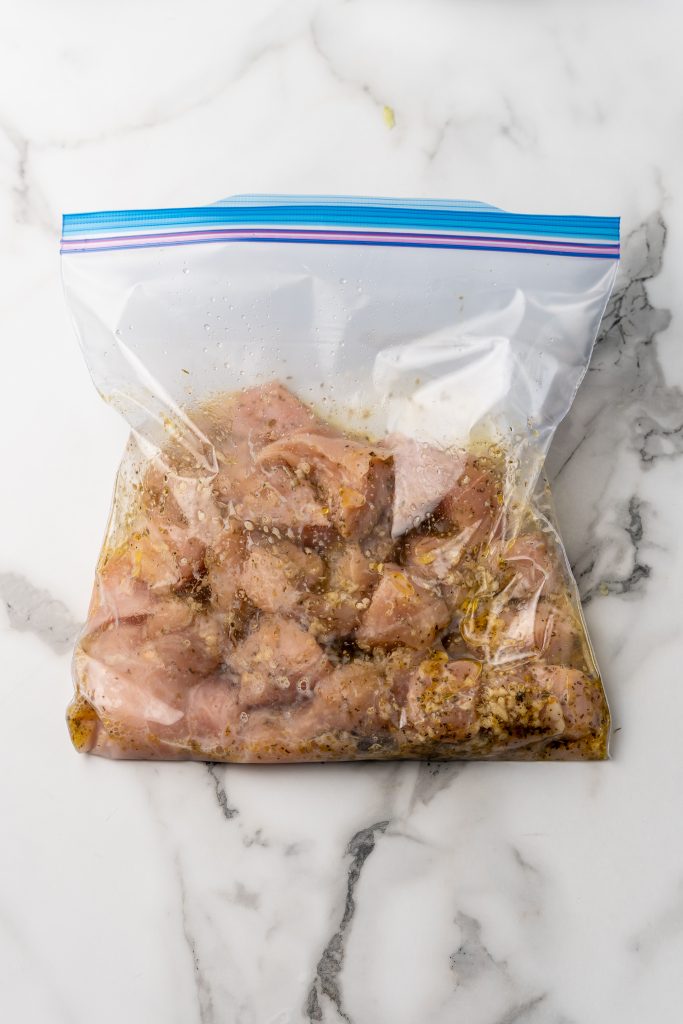 chunks of chicken in a ziplocking bag in a homemade Greek marinade