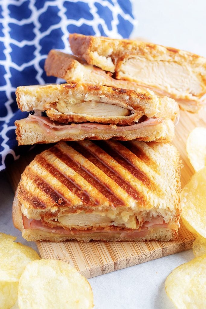 Chicken Cordon Bleu Paninis shown cut in half and fanned out on a wooden cutting board
