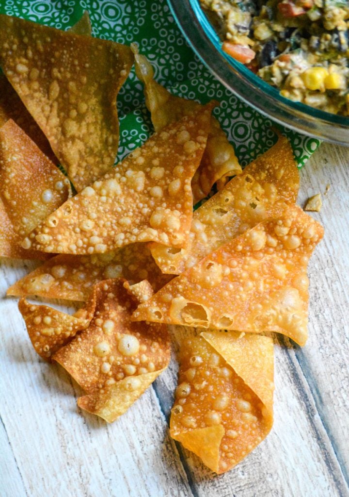 crispy fried wonton chips in a pile on a wooden table