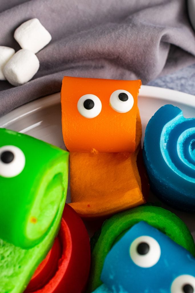 marshmallow pinwheel monster tongues with edible candy eyes on a white plate