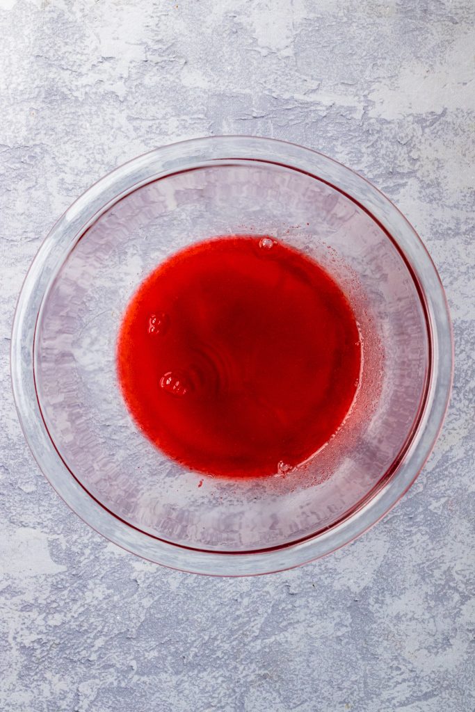 red liquid gelatin in a small glass bowl