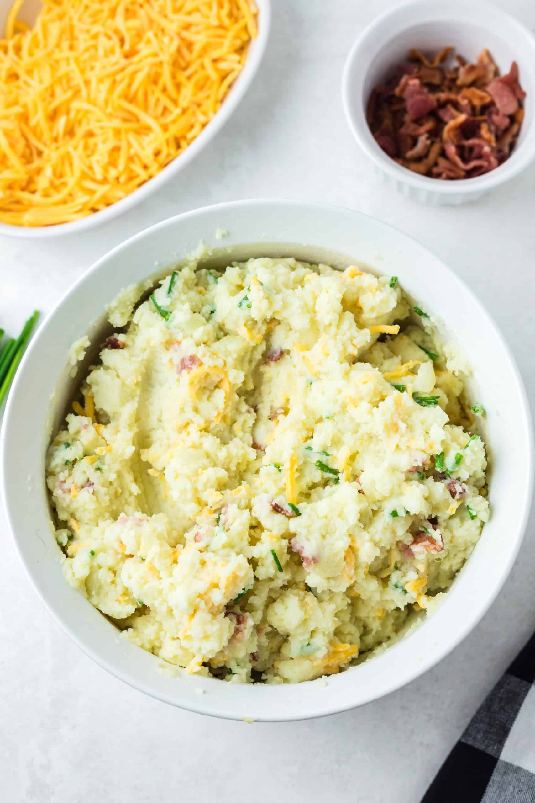 bacon cheddar and onion mashed potatoes in a white bowl