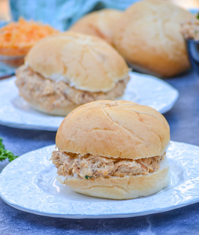 crockpot crack chicken sandwiches shown on white circular plates