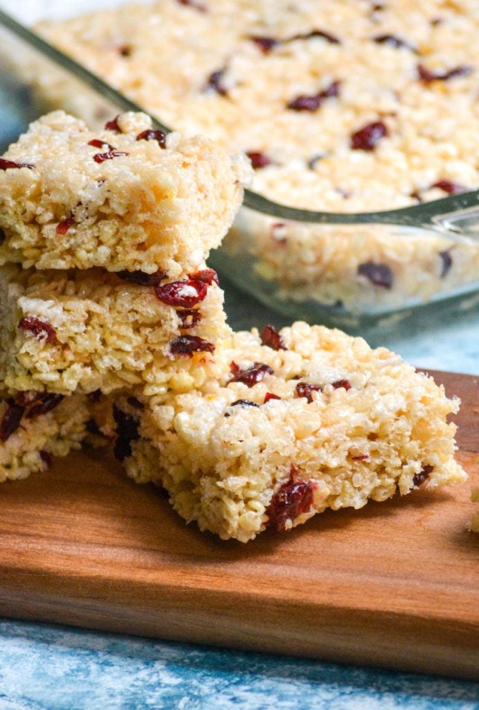 cranberry orange rice krispie treats squares served on a wooden cutting board