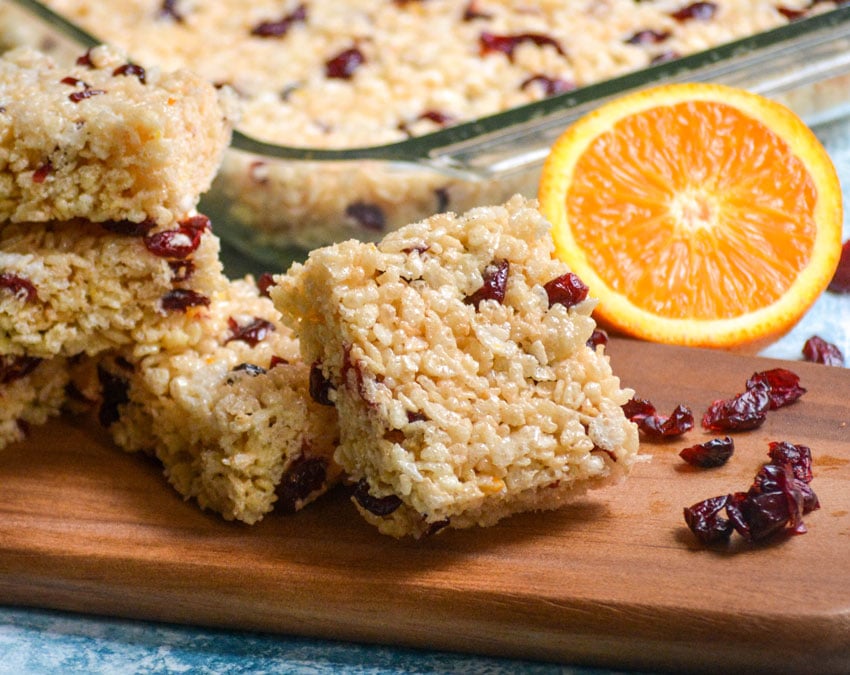 cranberry orange rice krispie treats squares served on a wooden cutting board