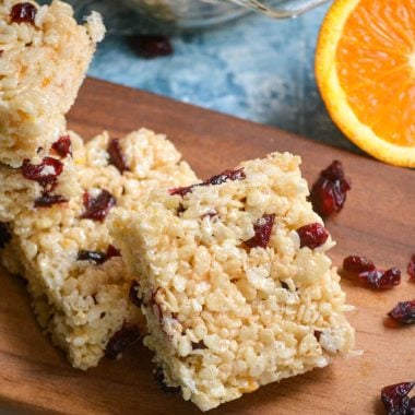 cranberry orange rice krispie treats squares served on a wooden cutting board