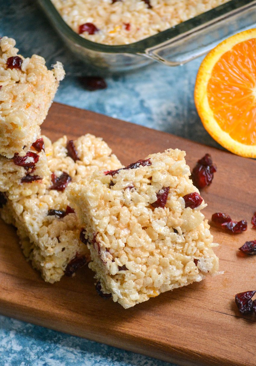 cranberry orange rice krispie treats squares served on a wooden cutting board