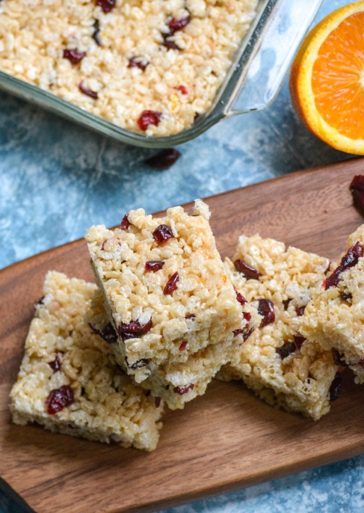 cranberry orange rice krispie treats squares served on a wooden cutting board