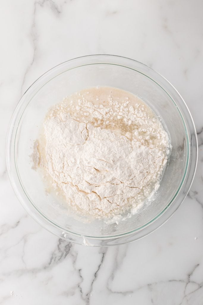 flour, yeast, and water in a large glass mixing bowl