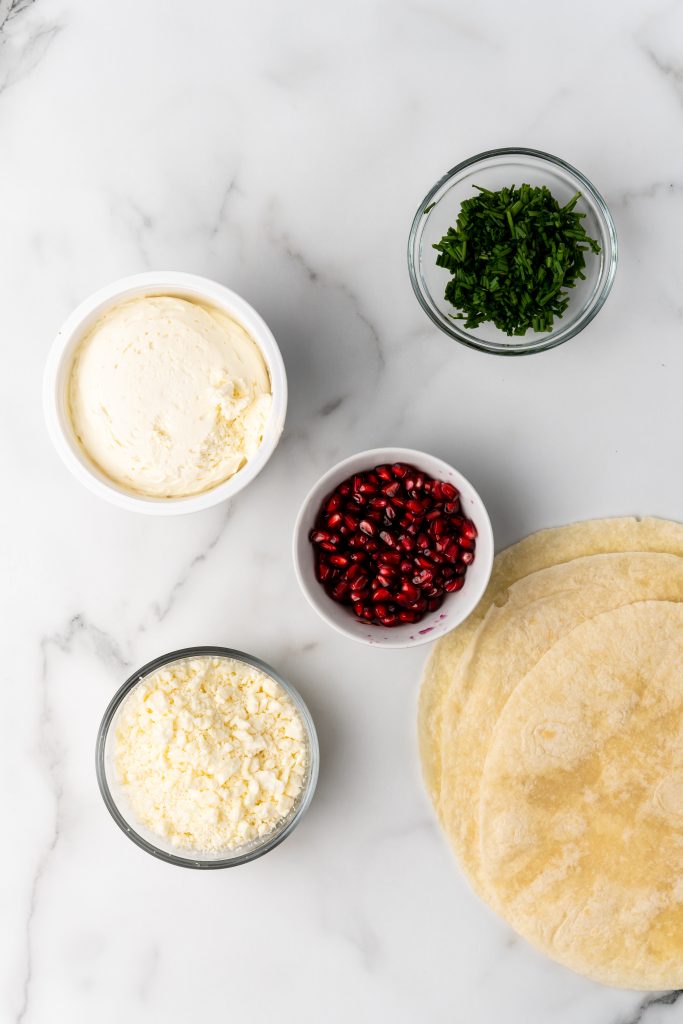 overhead image showing the measured ingredients needed to make a batch of pomegranate feta and chive pinwheels