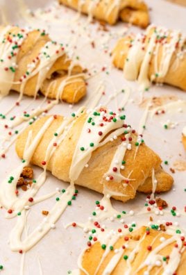 sprinkle topped white chocolate gingerbread crescent rolls on a piece of parchment paper