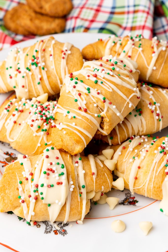 white chocolate gingerbread crescent rolls piled on a white serving platter