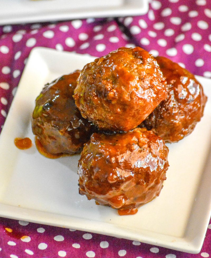 Slow Cooker Honey Buffalo Meatballs piled on a small square white appetizer plate