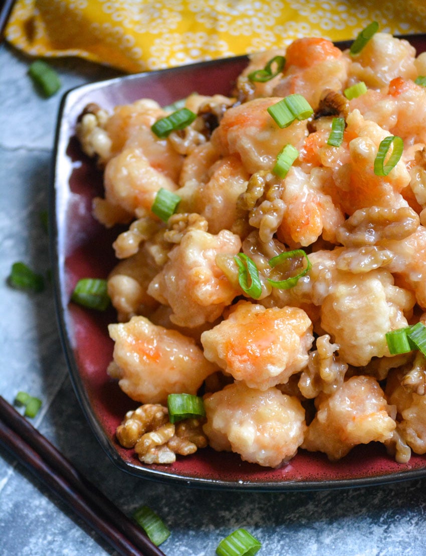 crispy honey walnut shrimp piled on a red and black square plate