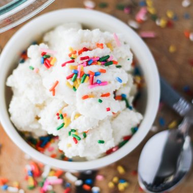 an overhead view of a white bowl full of snow cream ice cream topped with sprinkles