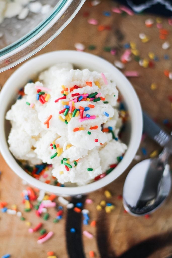 an overhead view of a white bowl full of snow cream ice cream topped with sprinkles