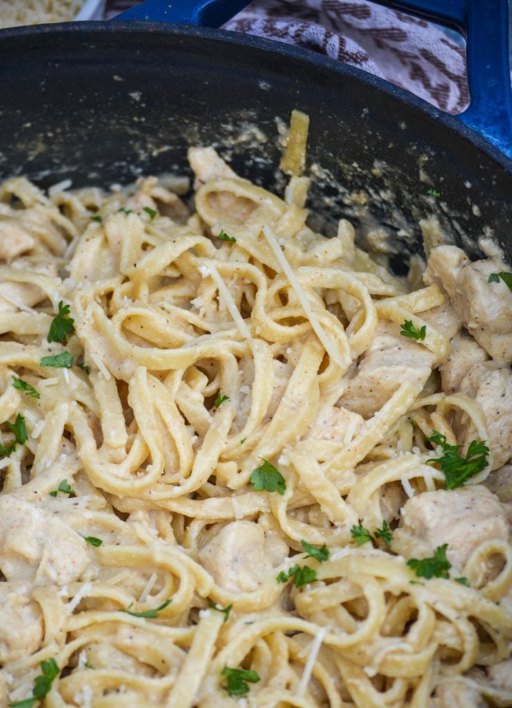 one pot Cajun chicken alfredo pasta in a large blue cast iron enameled dutch oven