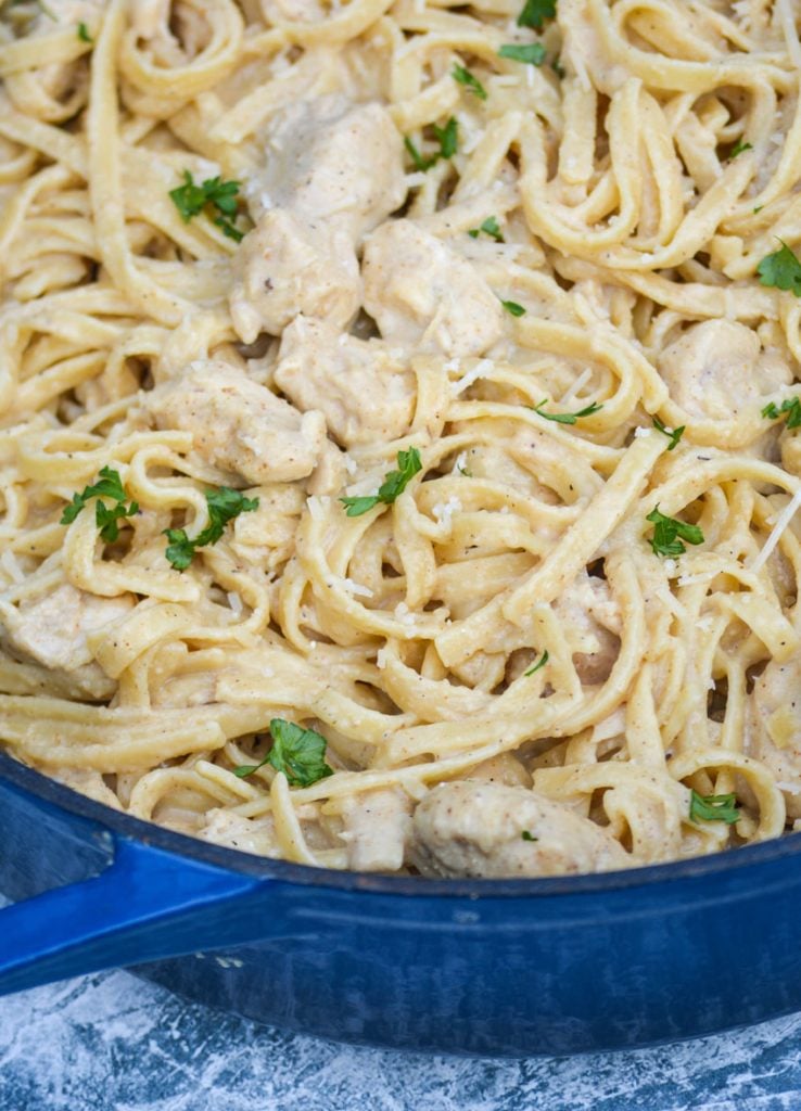 one pot Cajun chicken alfredo pasta in a large blue cast iron enameled dutch oven