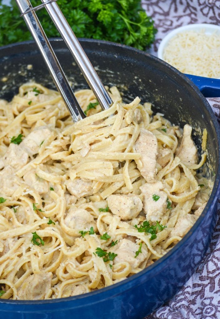 one pot Cajun chicken alfredo pasta in a large blue cast iron enameled dutch oven