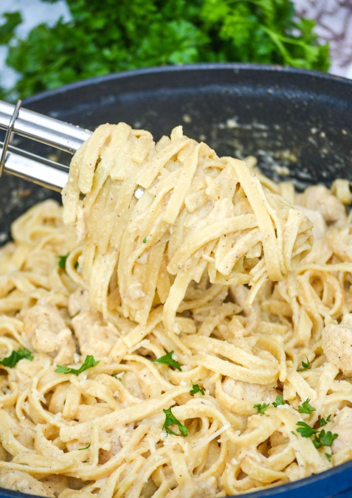 one pot Cajun chicken alfredo pasta in a large blue cast iron enameled dutch oven