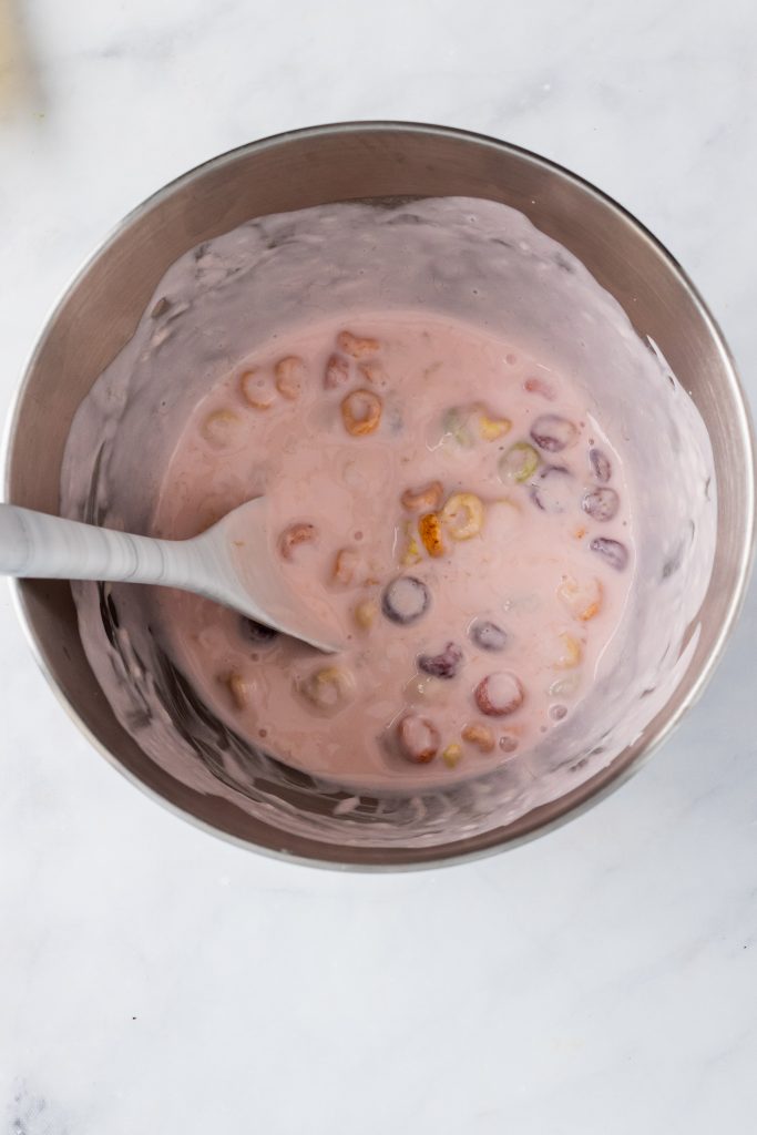 strawberry yogurt with cereal mixture in a metal mixing bowl
