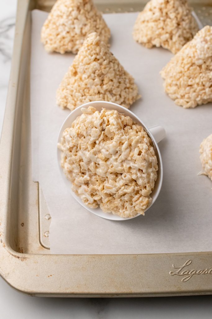 shaped rice krispie treats on a parchment paper lined baking sheet