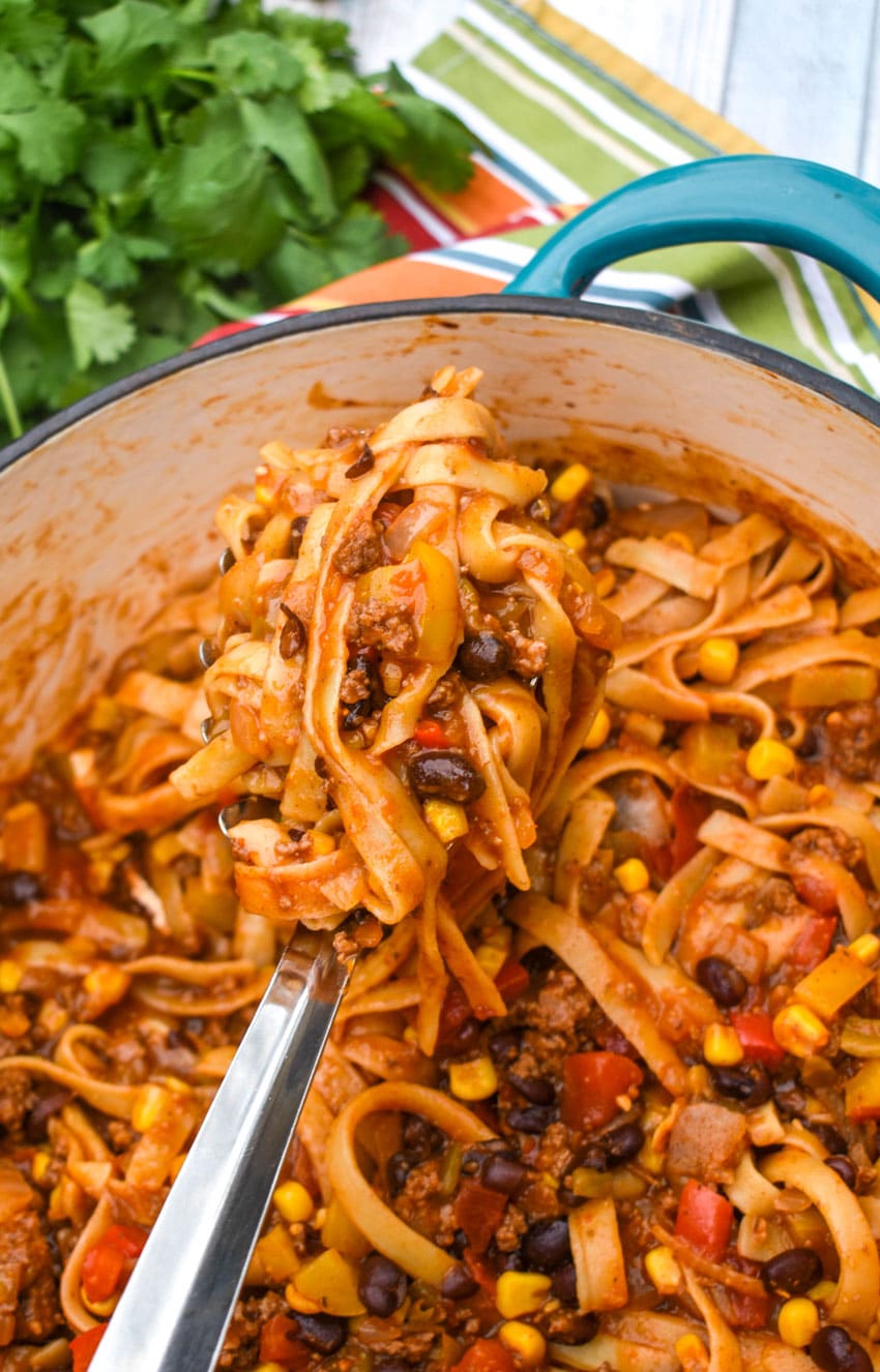 a silver spatula scooping one pot taco pasta out of a large dutch oven