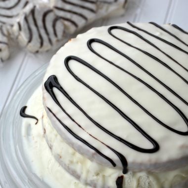 full size copycat little debbie zebra cake on a glass cake stand