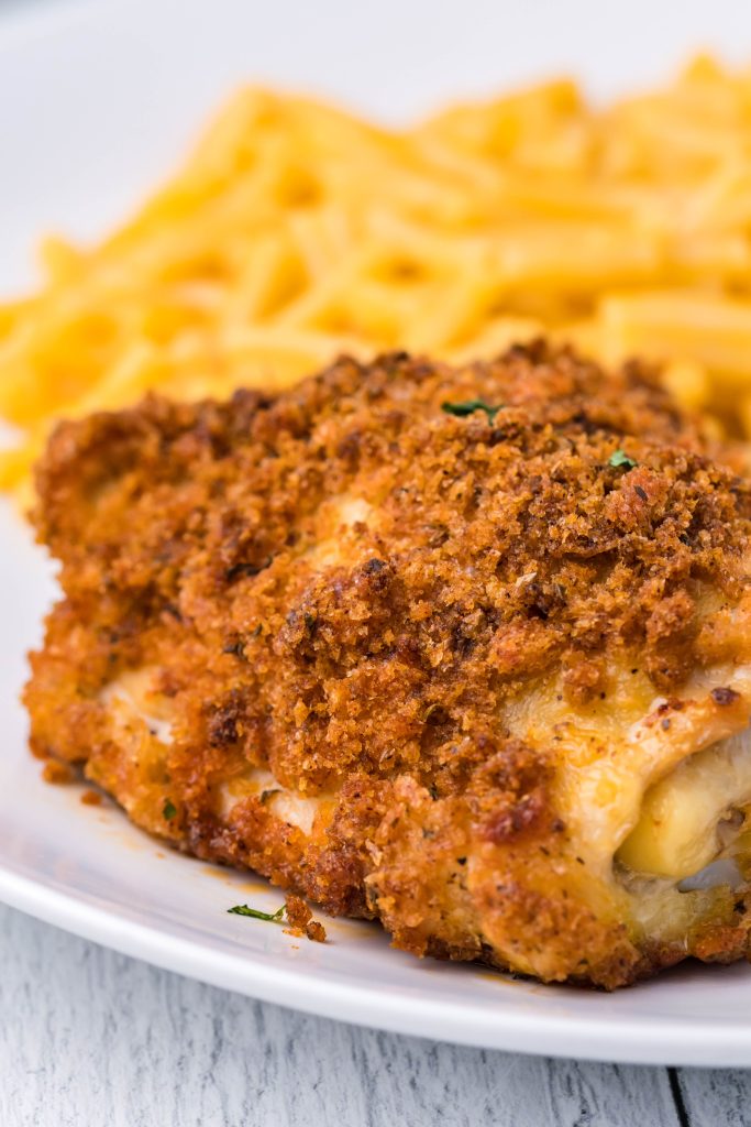 crispy oven fried chicken on a white plate next to macaroni and cheese
