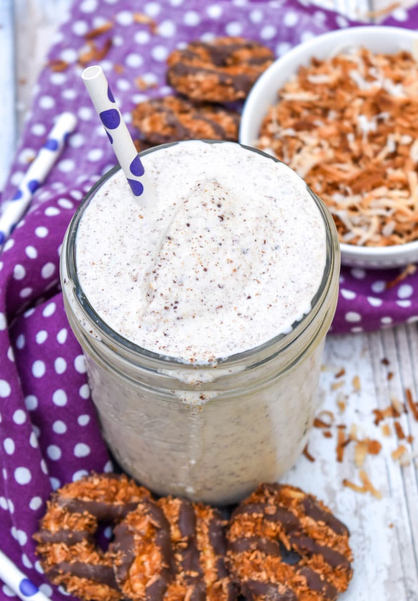a samoa cookie milkshake in a small glass jar on a wooden table