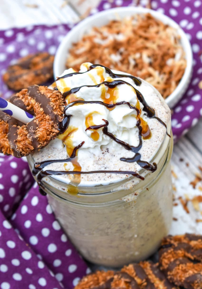 a samoa cookie milkshake in a small glass jar on a wooden table