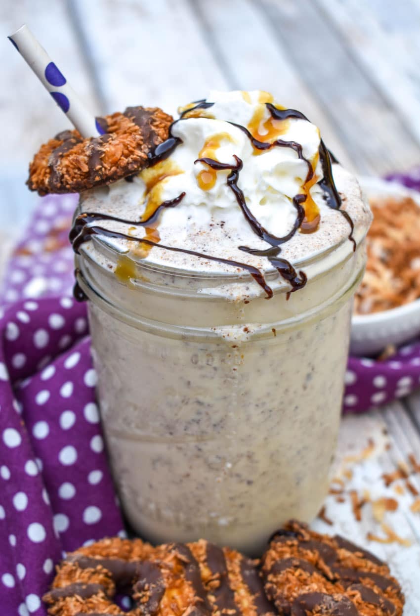 a samoa cookie milkshake in a small glass jar on a wooden table