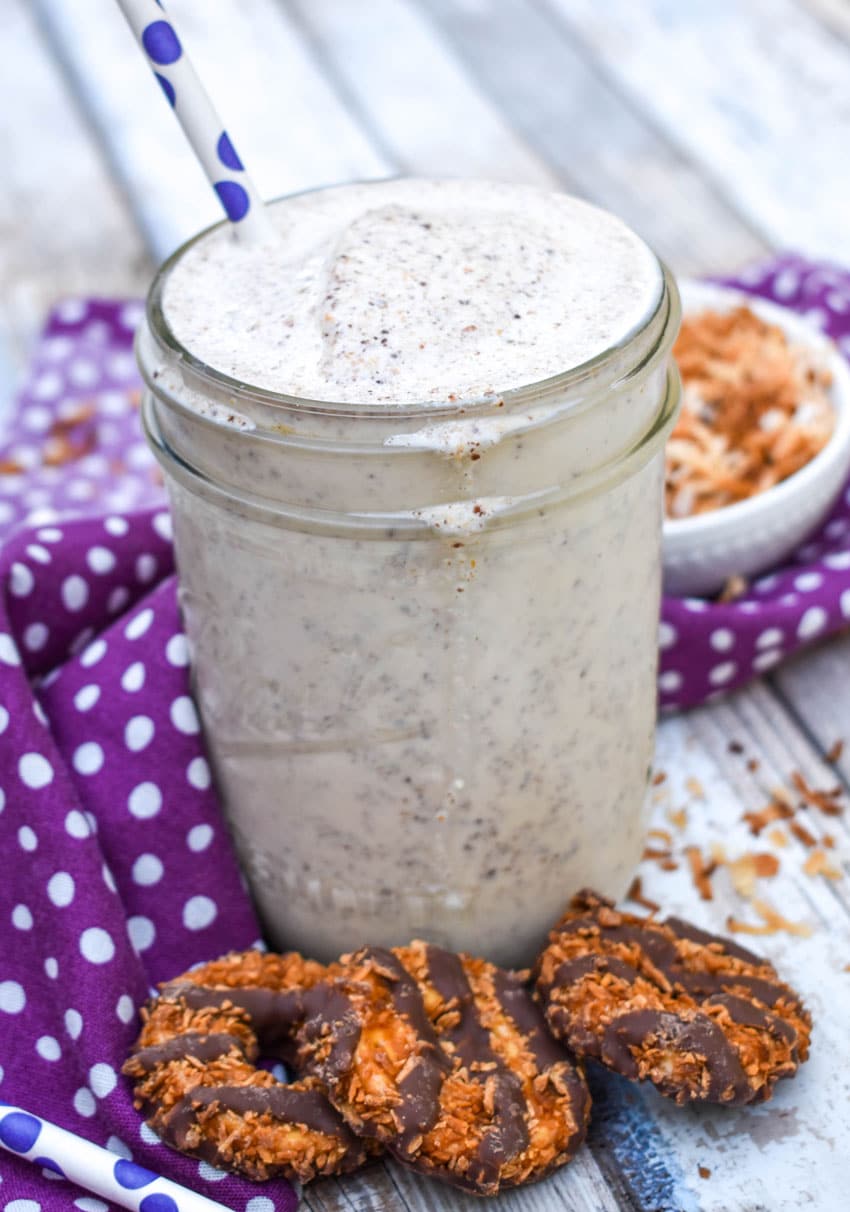 a samoa cookie milkshake in a small glass jar on a wooden table