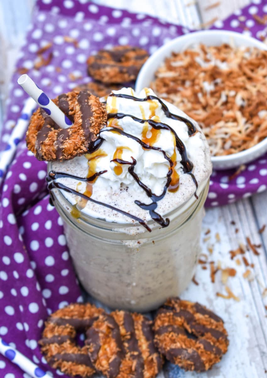 a samoa cookie milkshake in a small glass jar on a wooden table