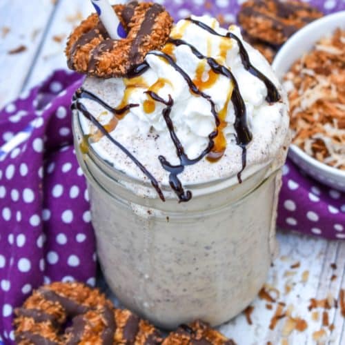 a samoa cookie milkshake in a small glass jar on a wooden table