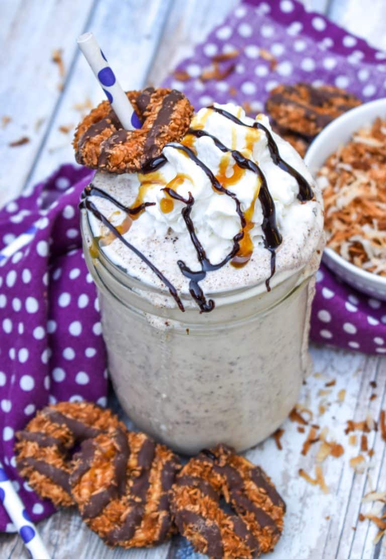 a samoa cookie milkshake in a small glass jar on a wooden table