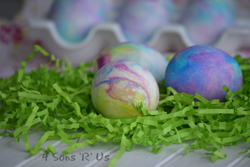 Shaving Cream Colored Easter Eggs on a bed of green crinkled strips of paper