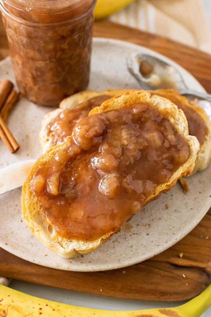 drunken monkey banana rum jam spread on two pieces of toast set on a white plate