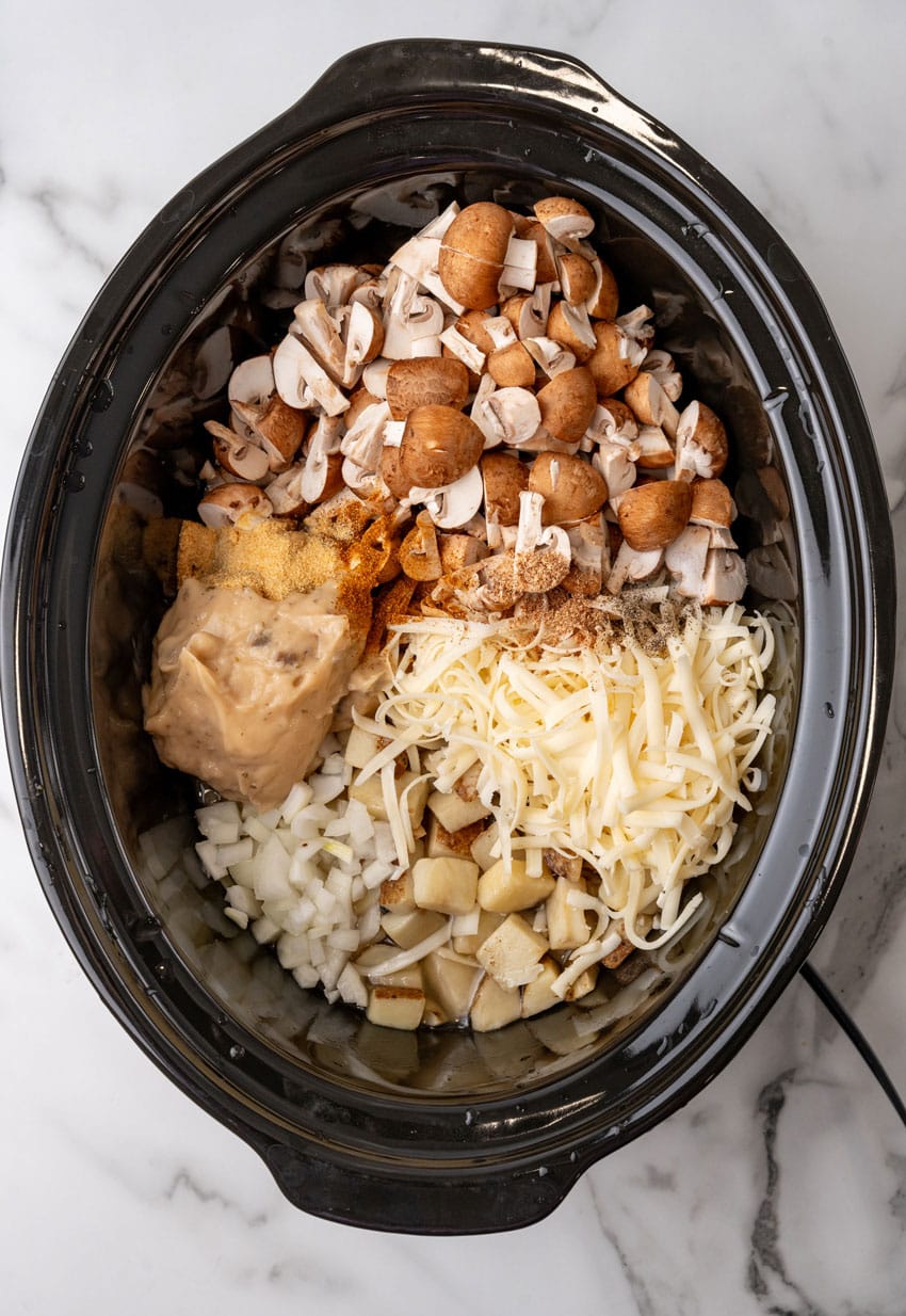 mushroom and swiss potato soup ingredients in the black bowl of a crockpot