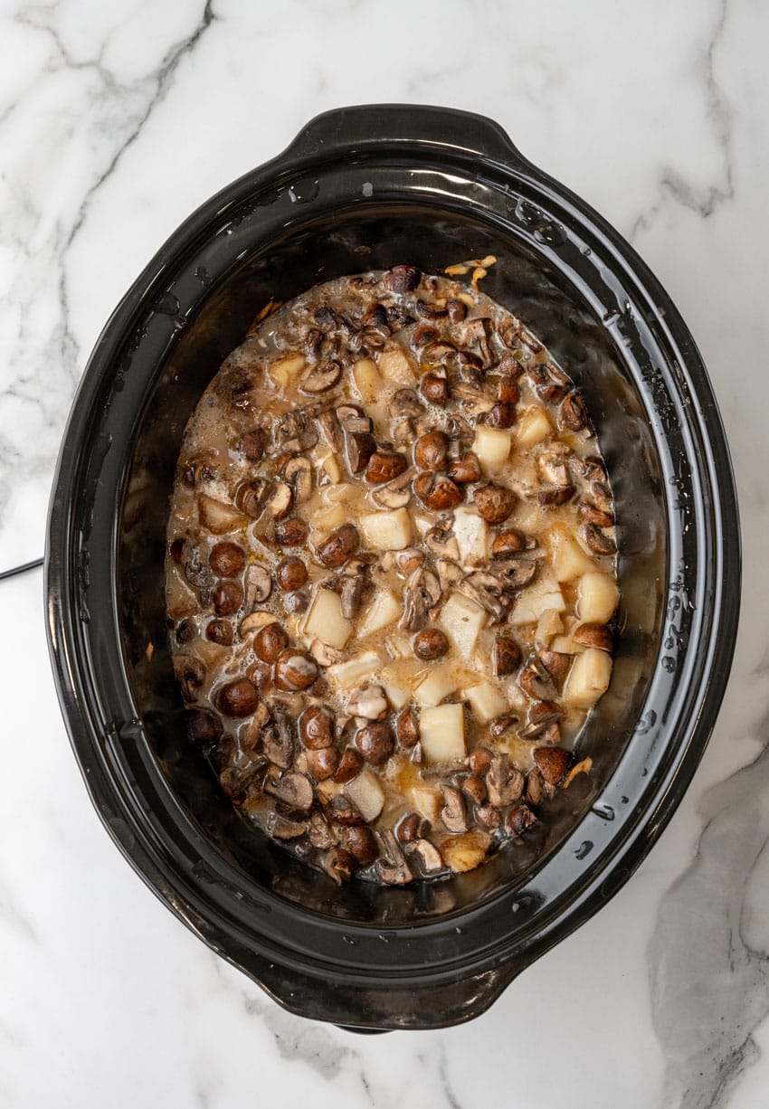 mushroom and swiss potato soup ingredients in the black bowl of a crockpot