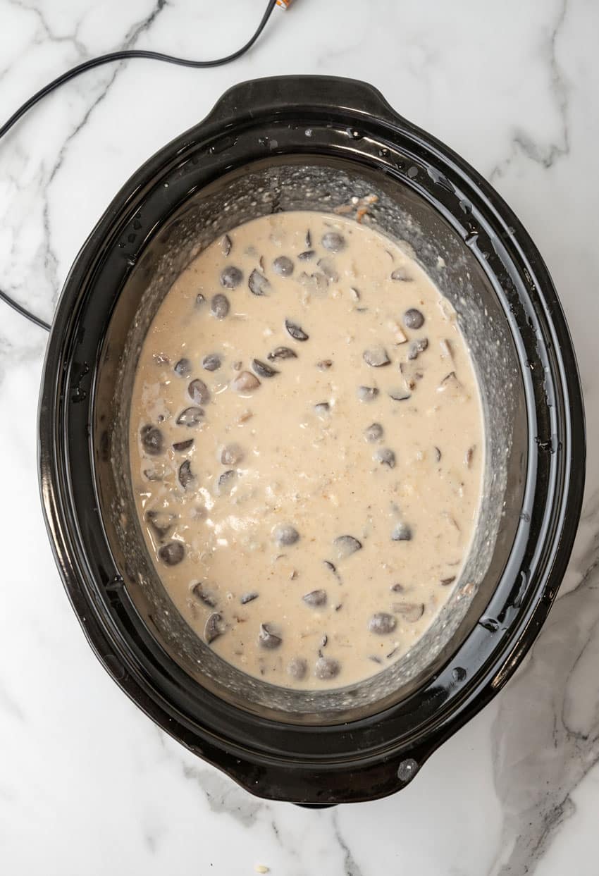 mushroom and swiss potato soup ingredients in the black bowl of a crockpot