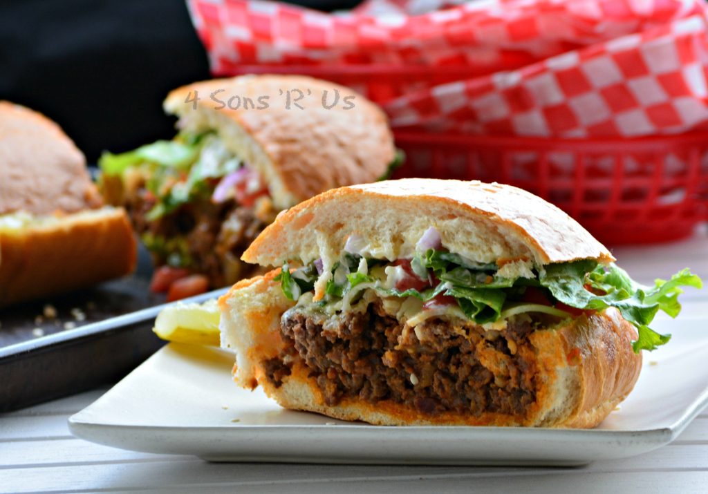 a sliced Bacon Cheeseburger Stuffed French Bread sandwich shown on a white plate