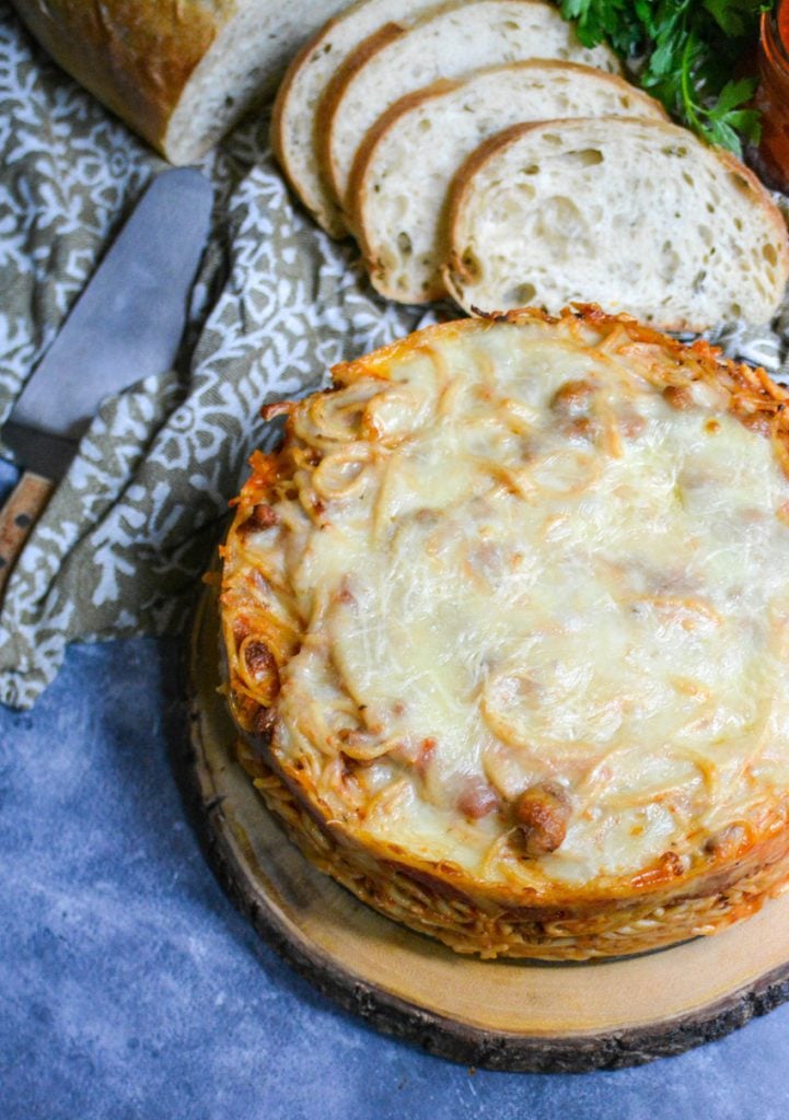 baked spaghetti pie served on a wooden cutting board