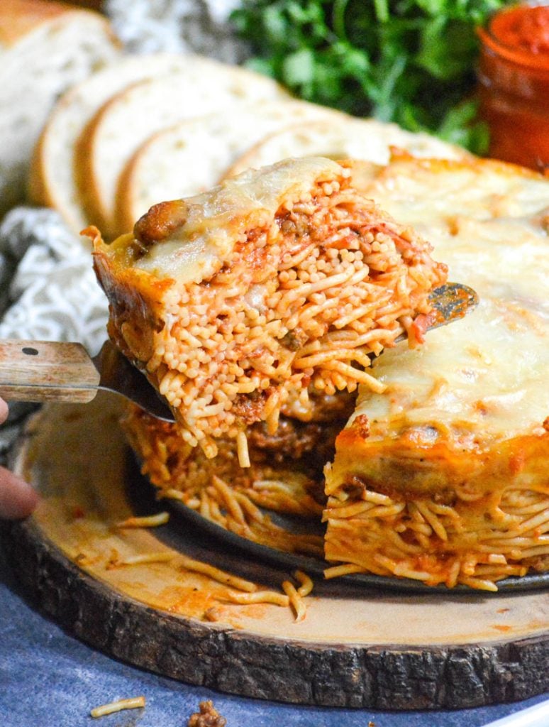 baked spaghetti pie served on a wooden cutting board