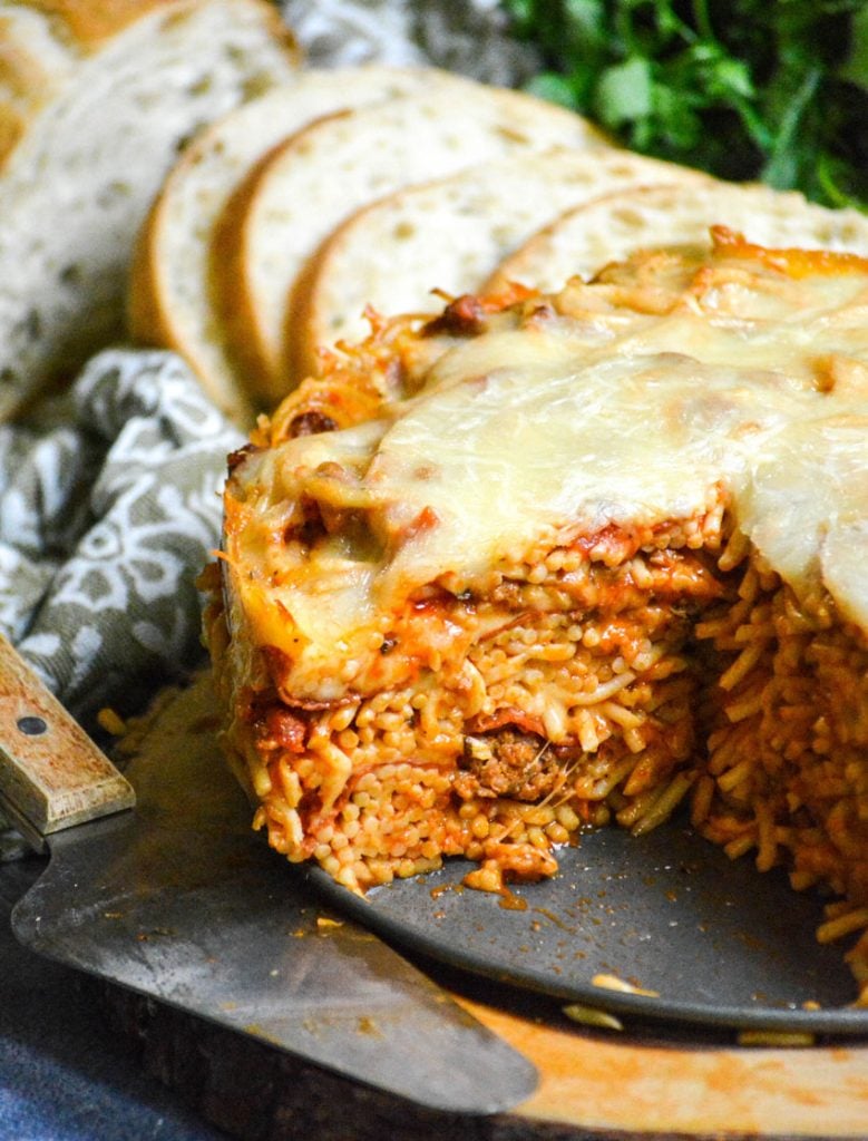 baked spaghetti pie served on a wooden cutting board