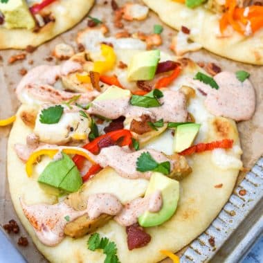 california chicken flatbread sandwiches on a large parchment paper lined baking sheet