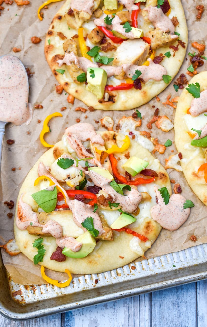 california chicken flatbread sandwiches on a large parchment paper lined baking sheet