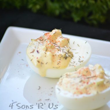 TWO CRAB STUFFED DEVILED EGGS ON A SMALL WHITE APPETIZER PLATE