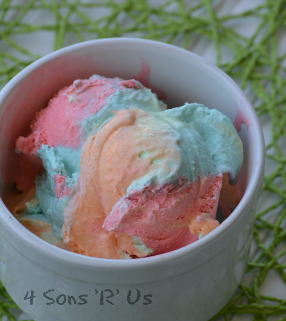 Jello Rainbow Sherbet Ice Cream in a white mug on a green place mat on top of a white table
